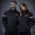Load image into Gallery viewer, Two people wearing black jackets with reflective stripes and a visible brand logo on a dark background.