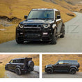 Load image into Gallery viewer, Silver Land Rover Defender 110 L663, fitted with Barugzai Falcon bodykit, parked on a road with a mountains and hills in the background. Fitted with Barugzai Sabre 22" alloy wheels in Gloss Black