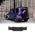 Load image into Gallery viewer, Rear quarter view of Purple Mercedes G Wagon G Class W463A SUV with gloss black wheels fitted with real Carbon Fibre BRBS style Rear Roof Spoiler in front of stacked pallets