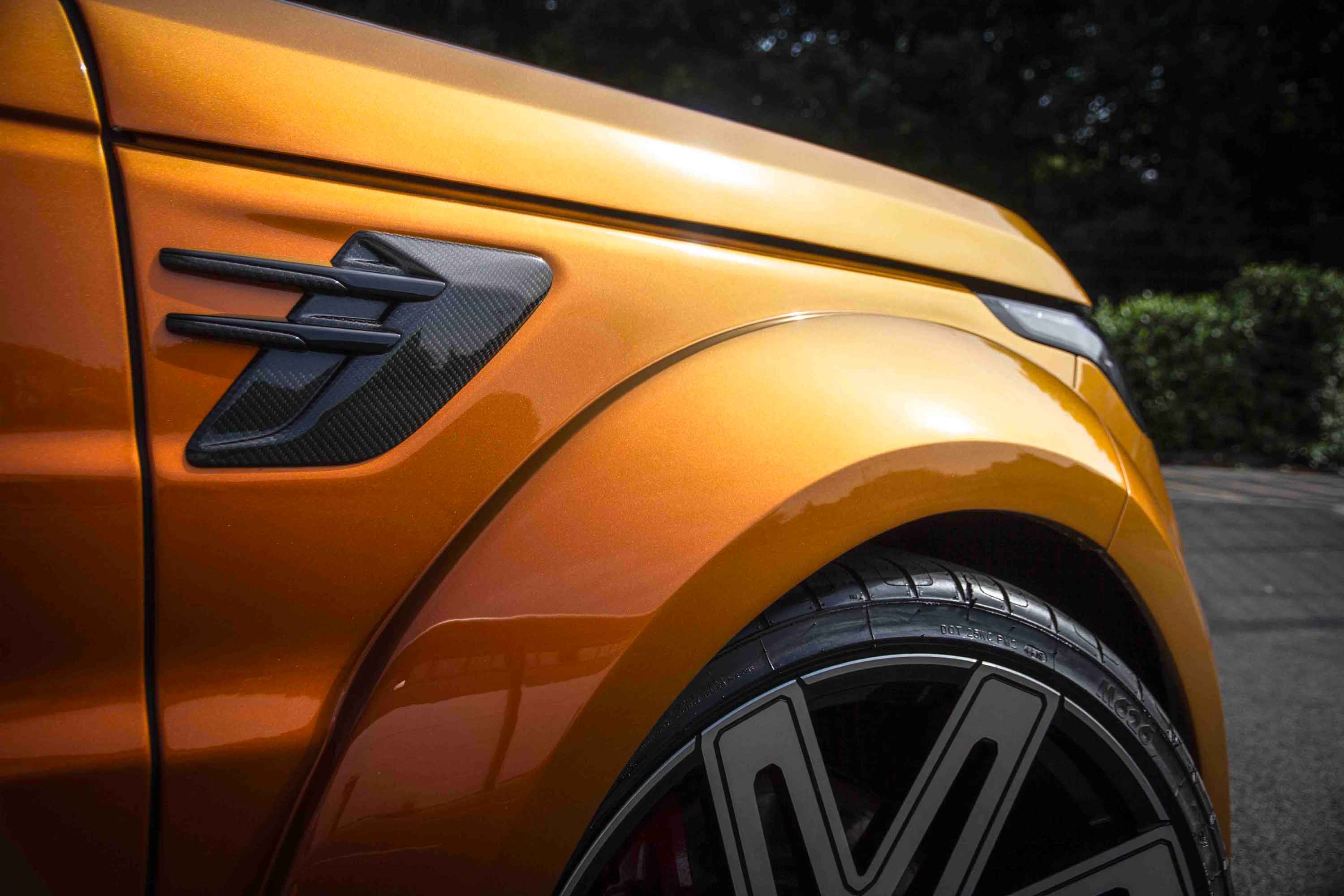 Close-up of a Range Rover Sport L494 fitted with Barugzai Cabaro II wide arch bodykit, sunburst orange paintwork with a Barugzai's EXEL 24