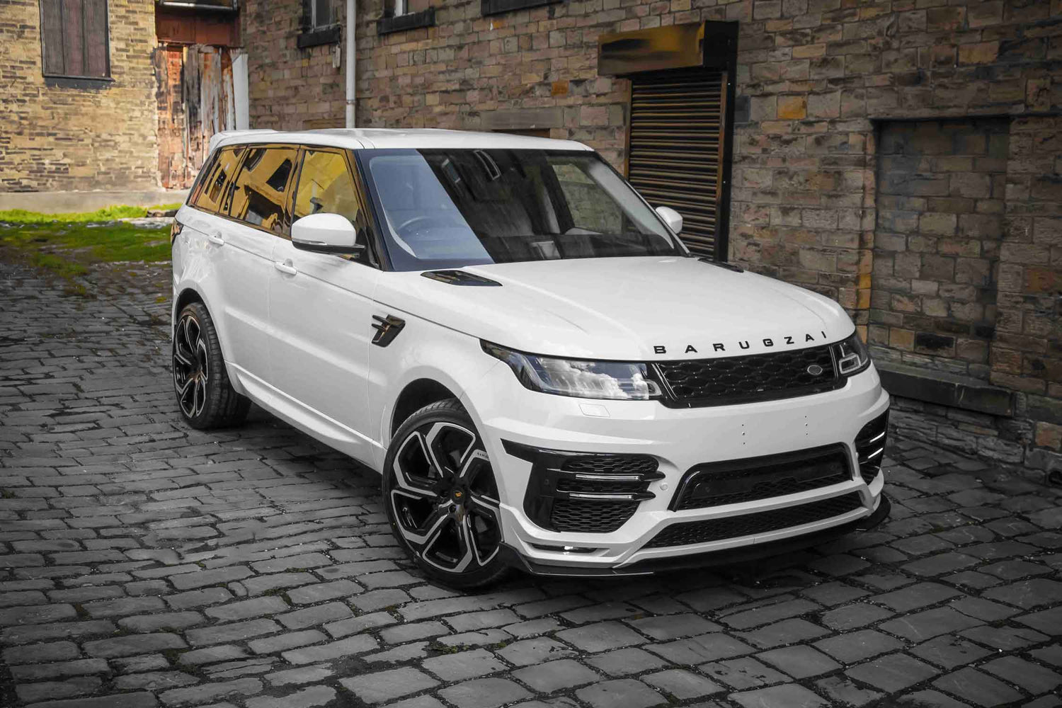 Front Quarter View of a White Range Rover Sport L494 fitted with Barugzai Sport Aero II bodykit on a cobblestone street.