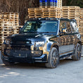Load image into Gallery viewer, Front quarter angle of Land Rover Defender showcasing Barugzai gloss black 22‑inch wheels and stance
