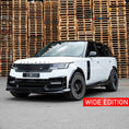Load image into Gallery viewer, ange Rover Vogue L460 2022+ in white and black with Barugzai Nebula bodykit and Vortex wheels, front quarter angle with stacked wooden crates in the background.
