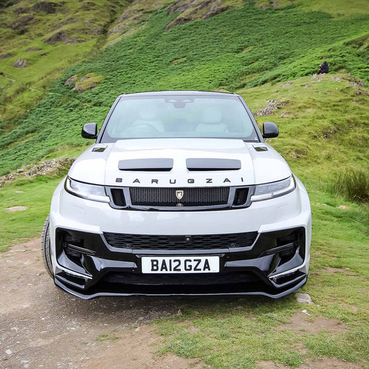 Head‑on front angle of Range Rover Sport L461 wearing the Barugzai Raptor bodykit, with a green hillside backdrop