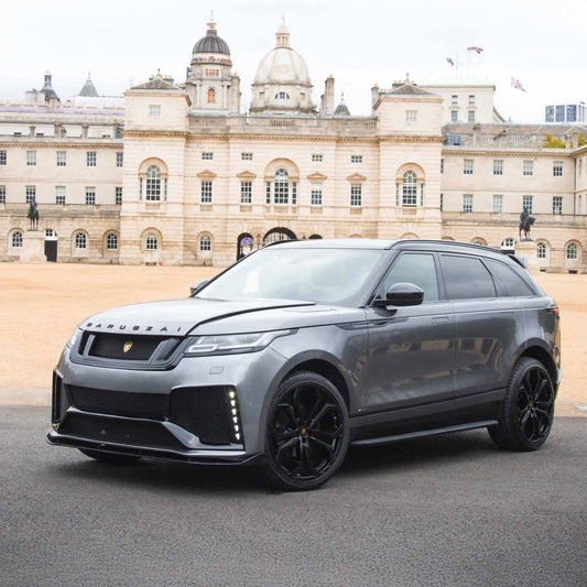 Range Rover Velar 2017 in Nardo Grey with Barugzai Huntress bodykit, front quarter angle, parked before a palace, fitted with Casanova wheels.