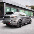Load image into Gallery viewer, Rear slightly lower quarter angle before glass‑fronted building with green tint, showing diffuser and exhaust surrounds.
