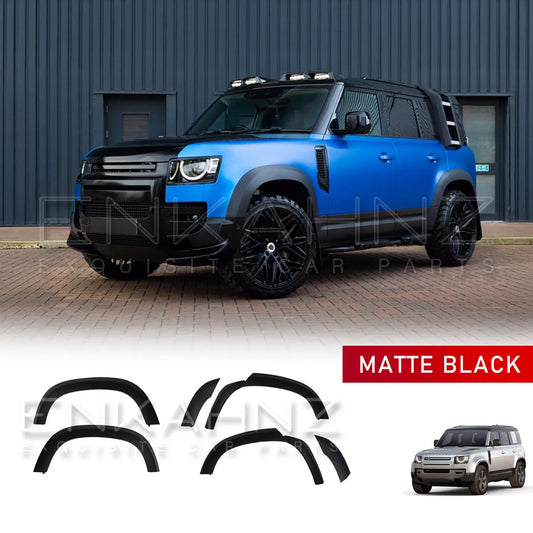 Front quarter view of a blue Defender 110 fitted with ENKAHNZ matte black wide wheel arches and Shuracan gloss black wheels, highlighting the aggressive styling and enhanced width.