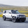 Load image into Gallery viewer, Front quarter shot from a distance, displaying the complete stance of the Defender 110 with the BARUGZAI Falcon kit, emphasizing its rugged, adventure-ready appeal.
