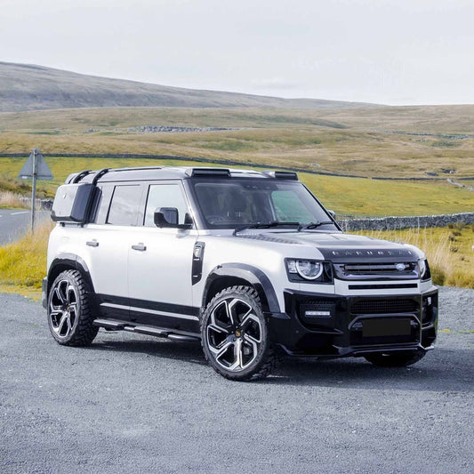 Front quarter shot from a distance, displaying the complete stance of the Defender 110 with the BARUGZAI Falcon kit, emphasizing its rugged, adventure-ready appeal.