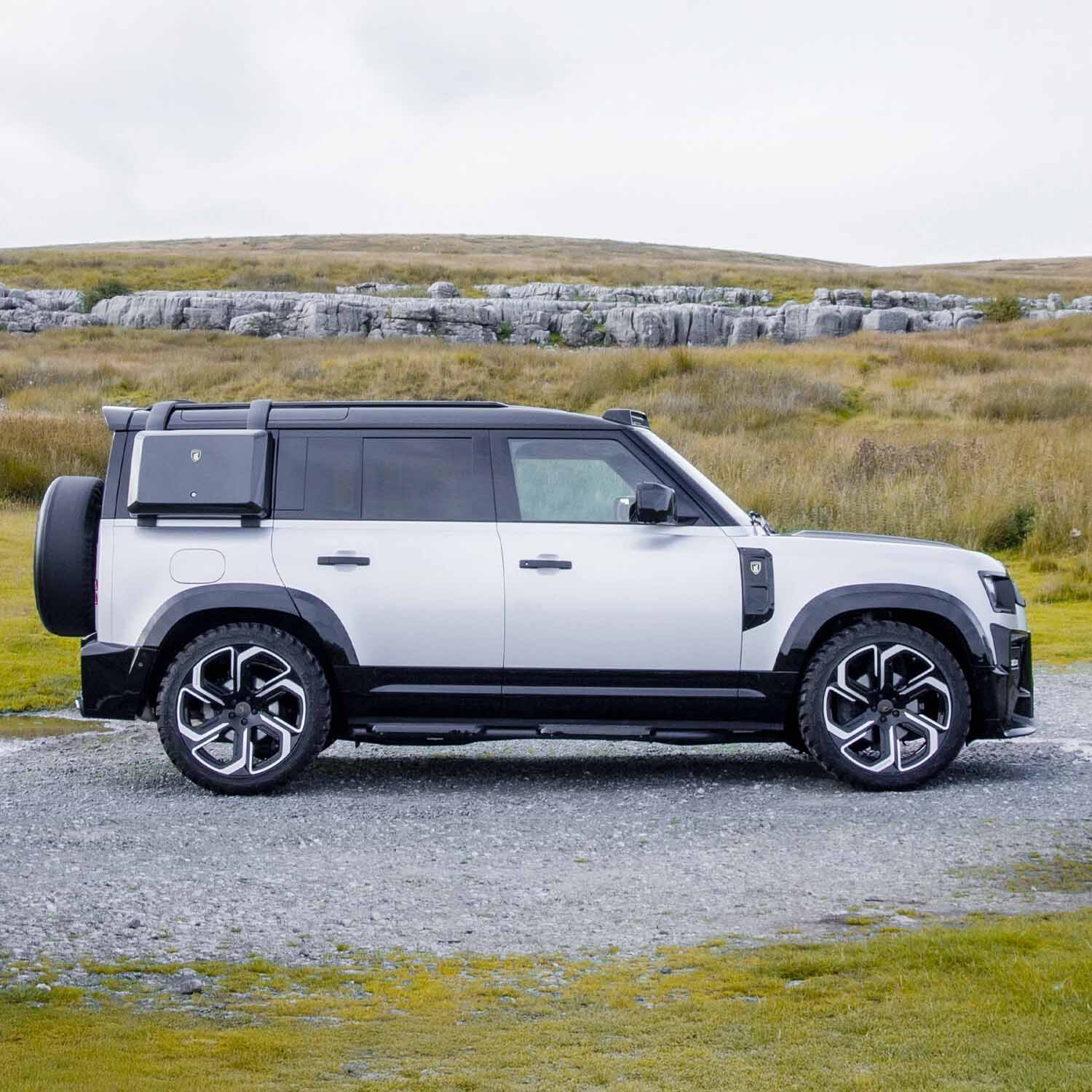 Side profile of the Defender 110 featuring the BARUGZAI Falcon bodykit, showcasing widened wheel arches, sporty side accents, and off-road capability.