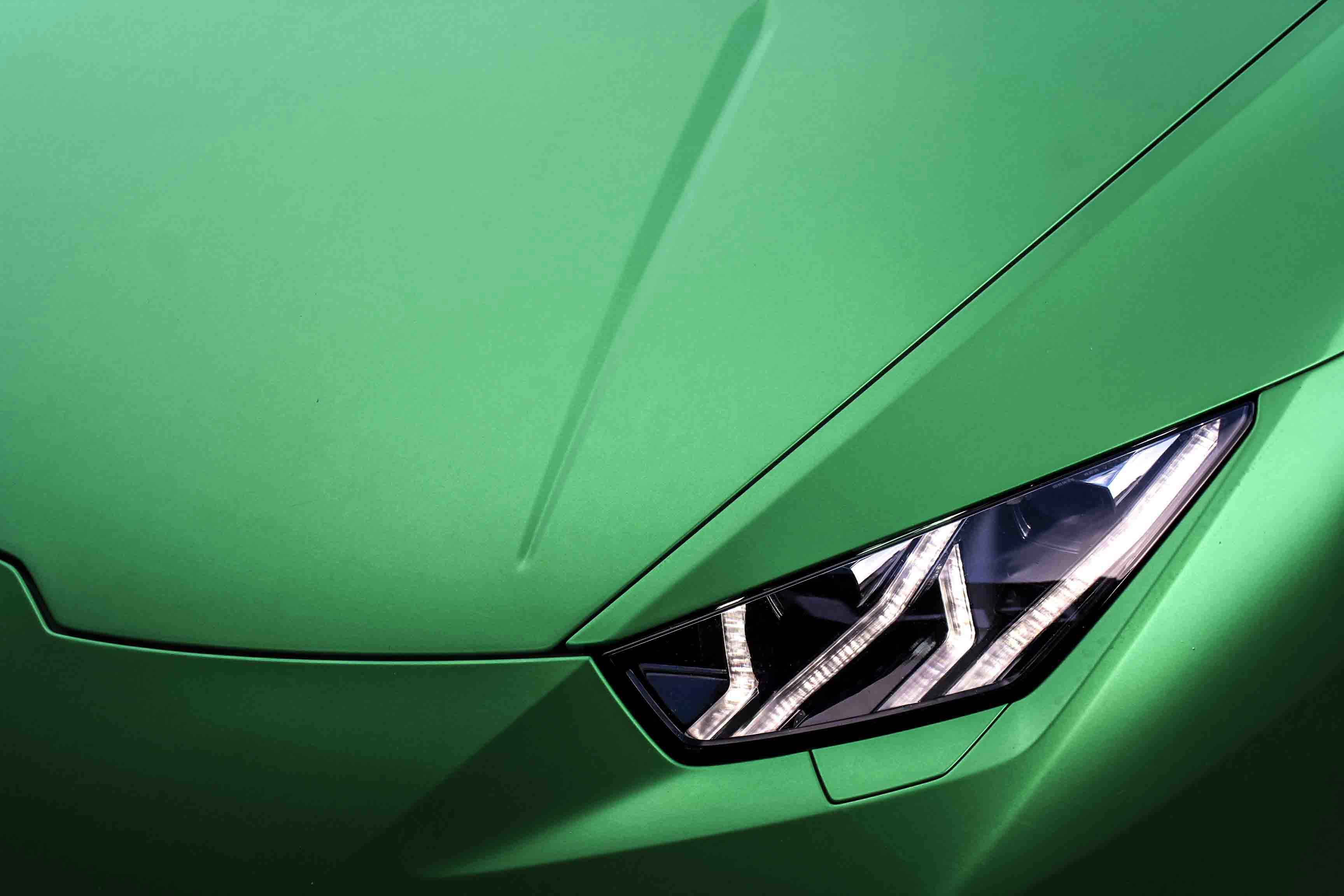 Close-up of a green Lamborghini Huracan headlight, vinyl wrap