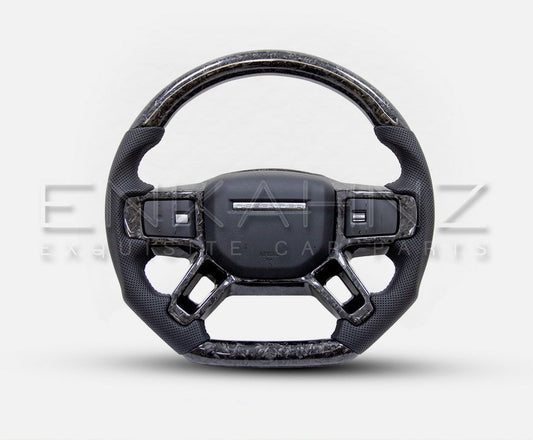 HEATED STEERING WHEEL FORGED CARBON FOR LAND ROVERDEFENDER STYLE 90 110 130 in a front angle with a white background. 