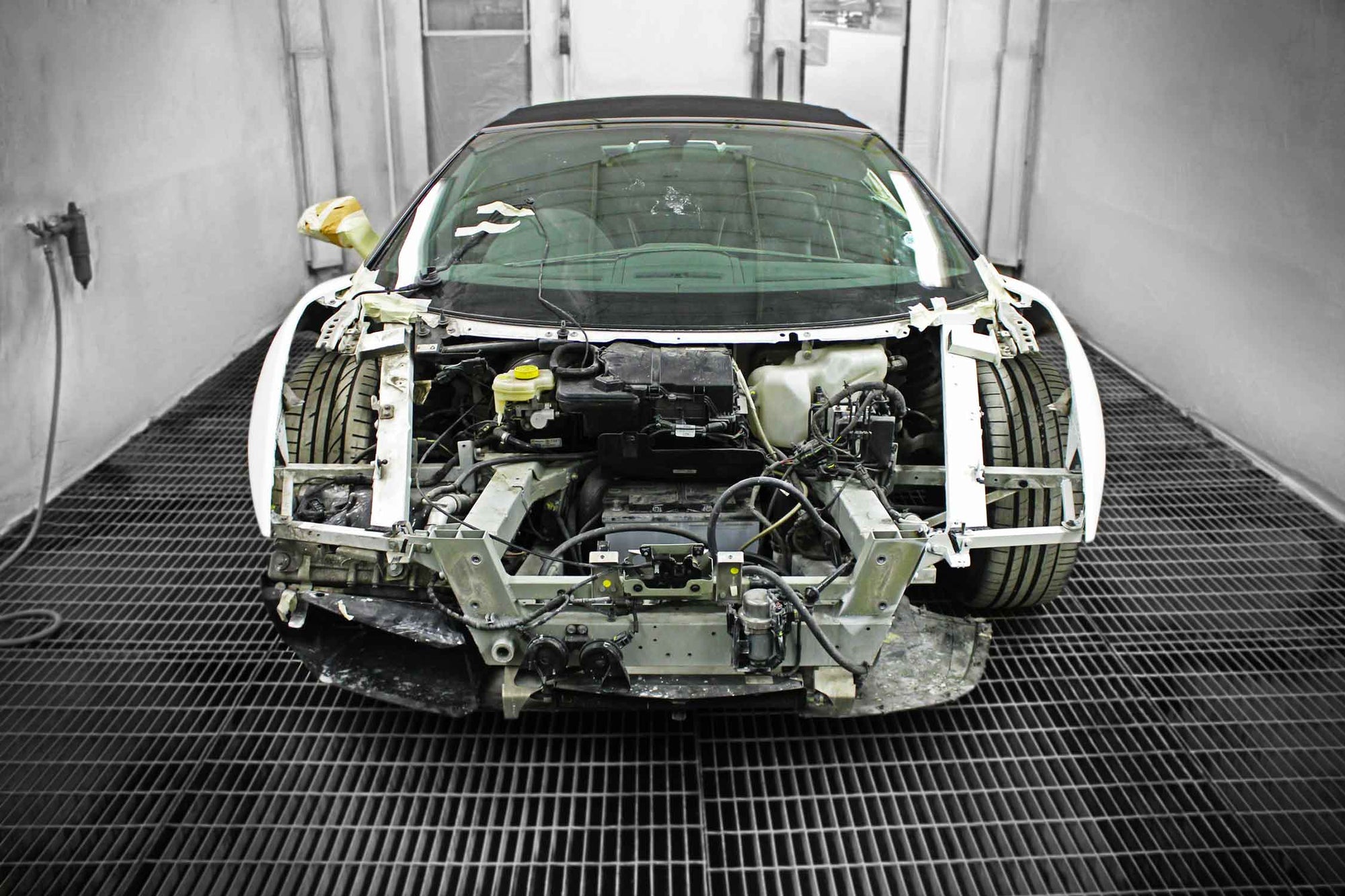 Damaged White Lamborghini Gallardo in a spray booth during paint process in Enkahnz