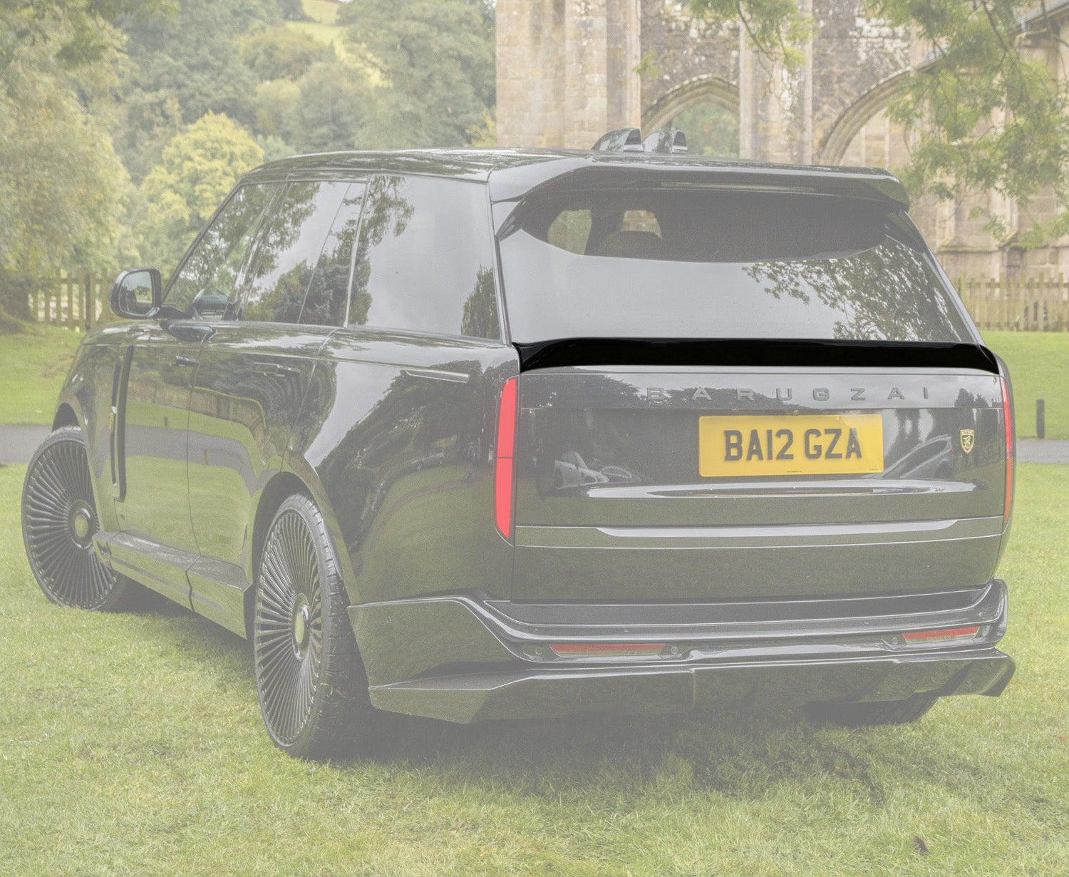 Quarter Rear View of a Black Range Rover Mid Boot Spoiler with an opaque white background of the rest of the car on the green grass.