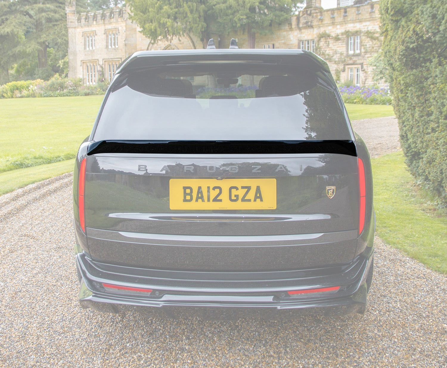 Rear View of the Mid Boot Spoiler of a black range rover vogue L460 2022+ at the entrance of the house, with the rest of the background and car in opaque white background. 