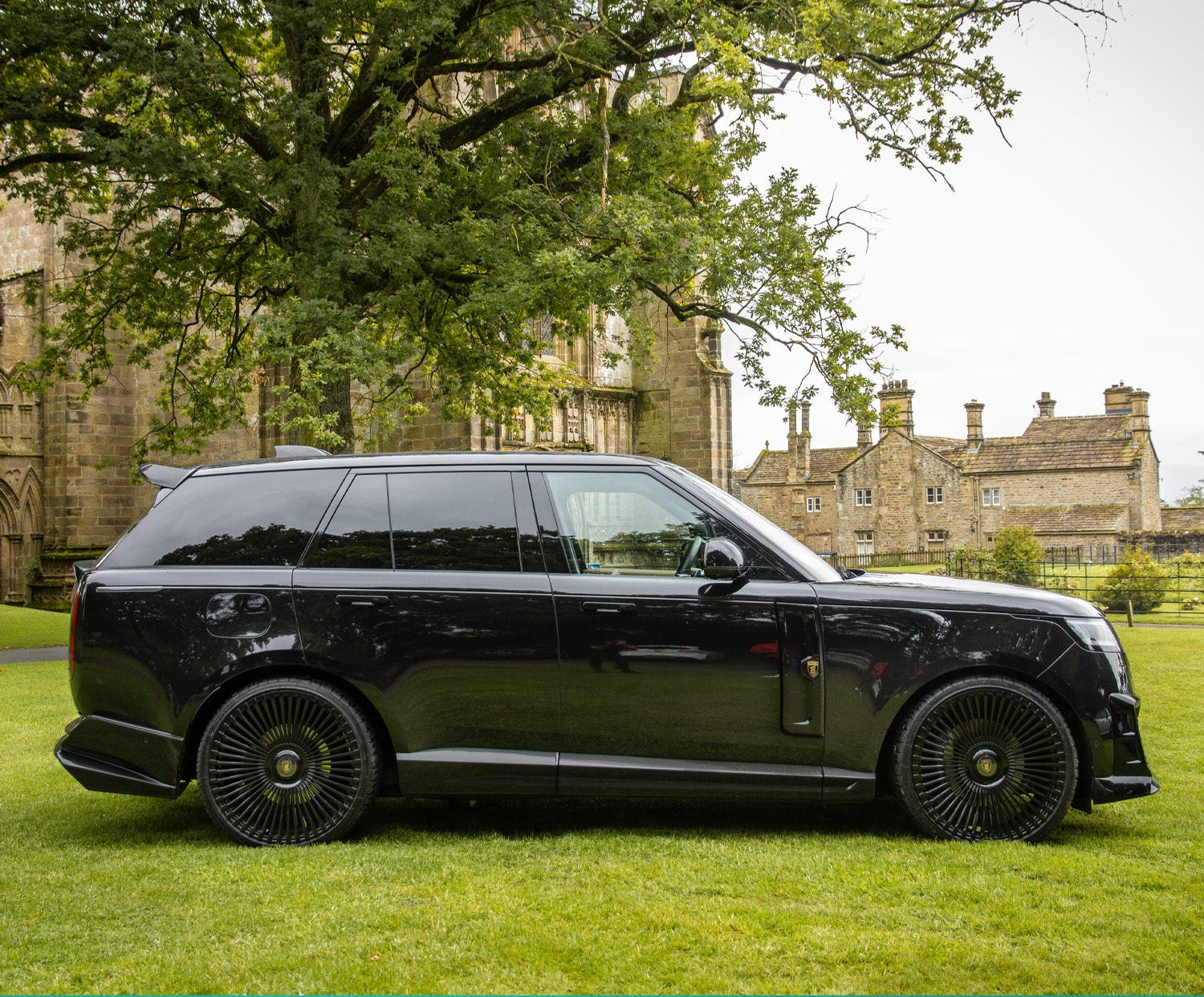 Side View of the Black Range Rover Vogue L460 2022+ on the green grass with Barugzai Branding.