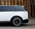 Load image into Gallery viewer, Close Up Side View of a Gloss Black and White Range Rover Vogue L460 2022+ in a warehouse setting with Enkahnz Branding.
