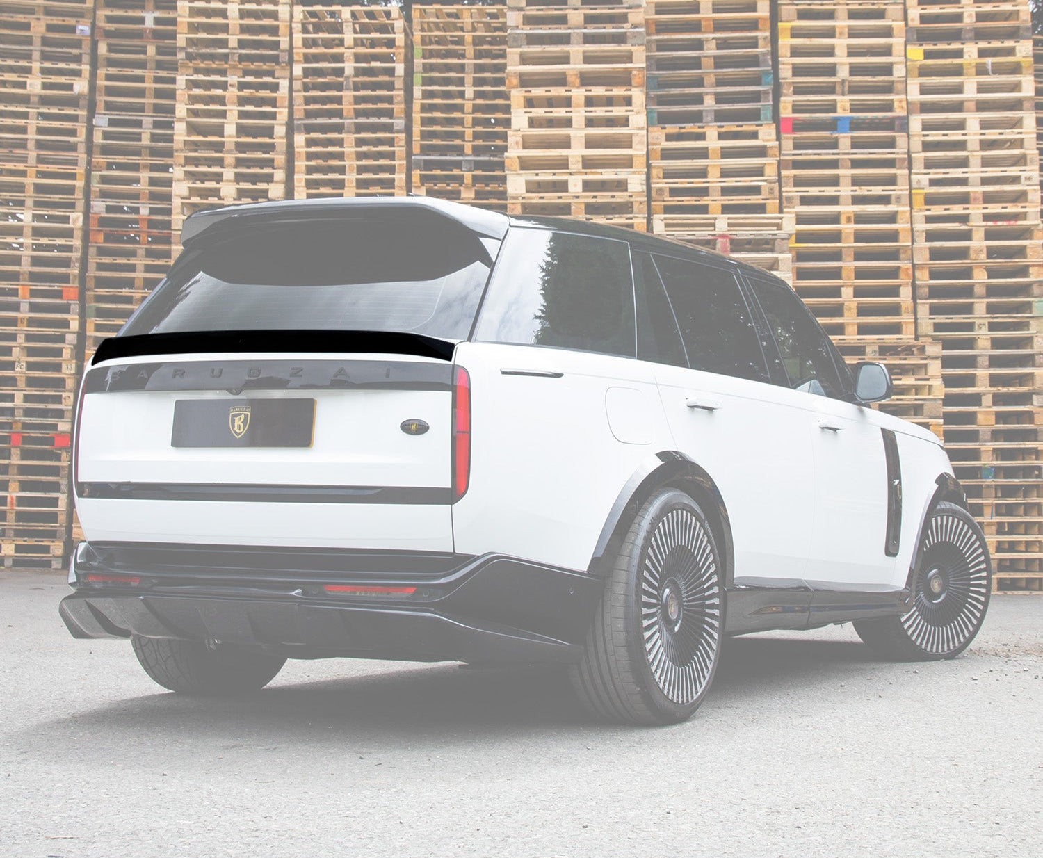 Rear Quarter View of a Gloss Black and White Range Rover Vogue L460 2022+ Mid Boot spoiler in an opaque white warehouse setting with Enkahnz Branding.