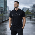 Load image into Gallery viewer, Enkahnz Trademark Polo T-Shirt – Black in a road setting.

