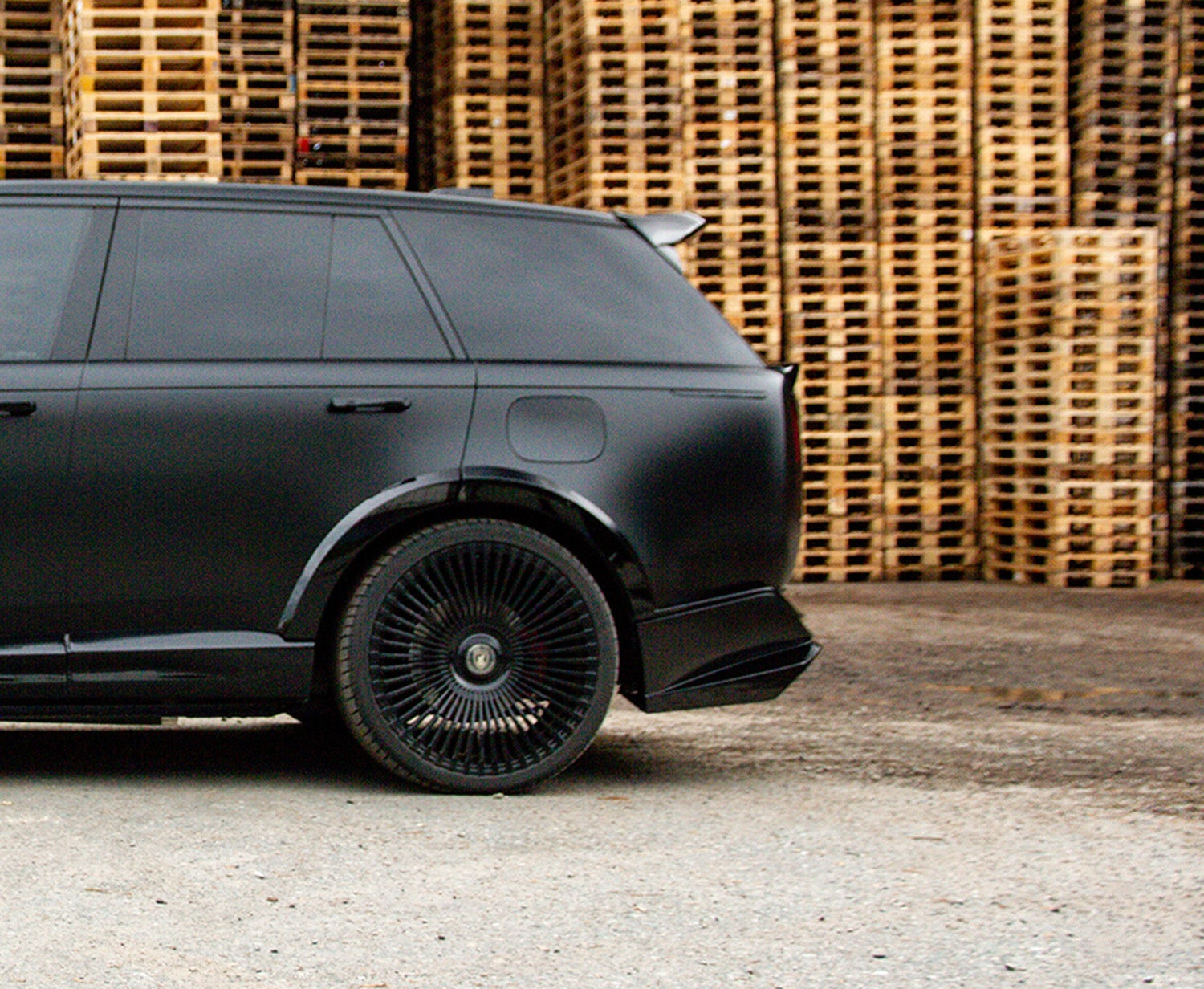 Side View of a Gloss Black Range Rover Vogue 2022+ L460 in a warehouse setting with Enkahnz.
