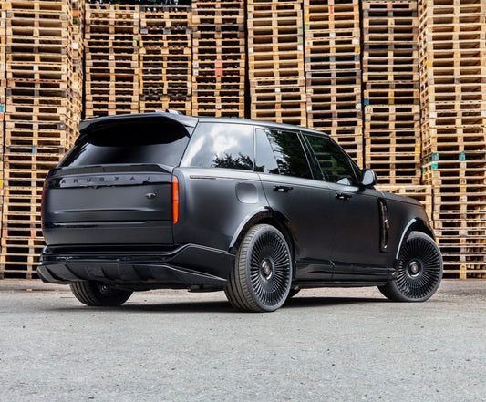 Rear Quarter View of a Gloss Black Range Rover Vogue L460 2022+ in a warehouse setting with Enkahnz Branding.