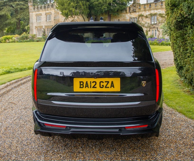 Rear view of a gloss black range rover vogue L460 2022+ at the entrance of a house. 