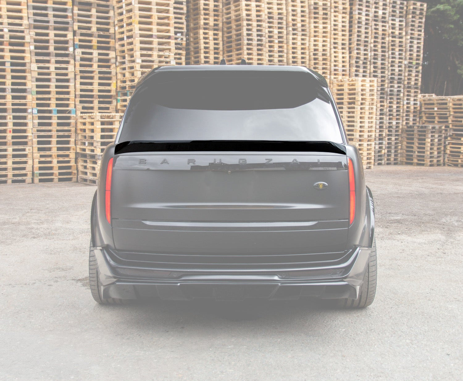 Gloss black Mid Boot Spoiler of a Range Rover Vogue L460 2022+ in an opaque white background of the range rover in a ware house background with Enkahnz Branding. 