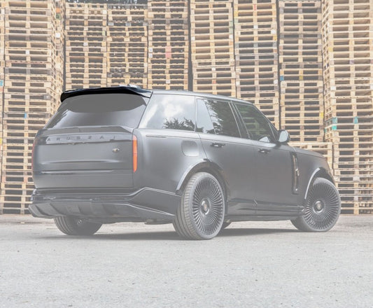 Rear Quarter View of the Range Rover Vogue L460 2022+ Gloss Black Roof Spoiler depicted on a white opaque background of the car in a warehouse setting.