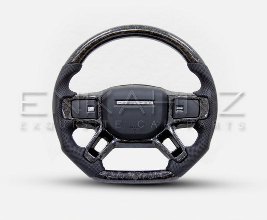 STEERING WHEEL FORGED CARBON FOR LAND ROVER DEFENDER STYLE 90/110/130 (2020+) with the product in the bottom with a white background. 