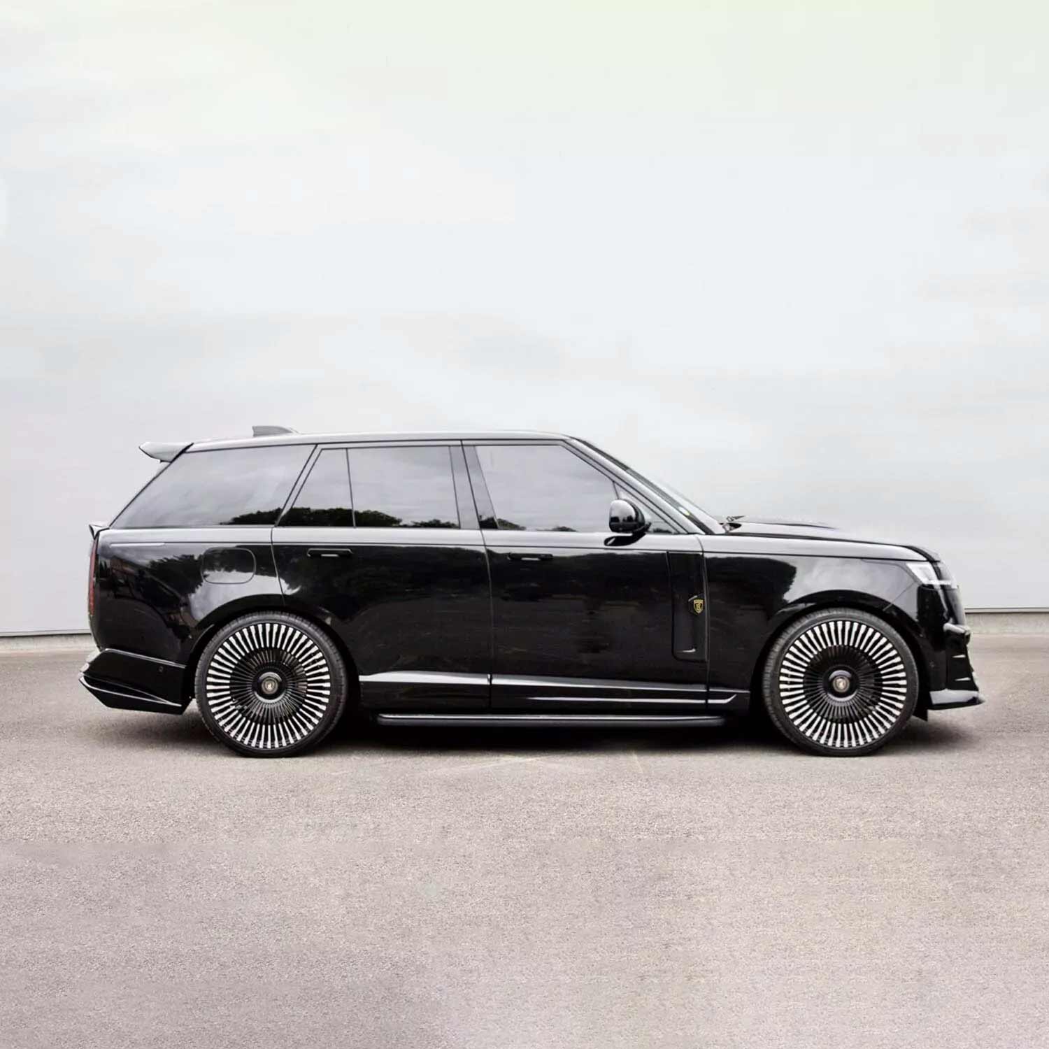 Black Range Rover L460 2022, fitted with Barugzai Nebula bodykit, shown side view, parked on a road with a grey background. Fitted with Barugzai Vortex Forged 24" alloy wheels in Gloss Black Polished
