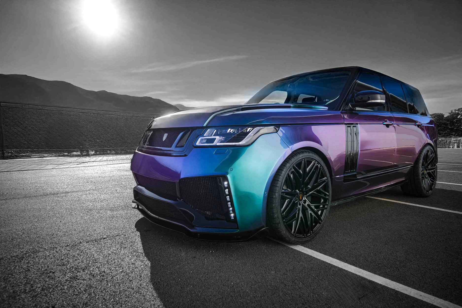 Multicolored Chameleon paint work Range Rover L405, fitted with the Barugzai Bison bodykit on a road with a mountainous background