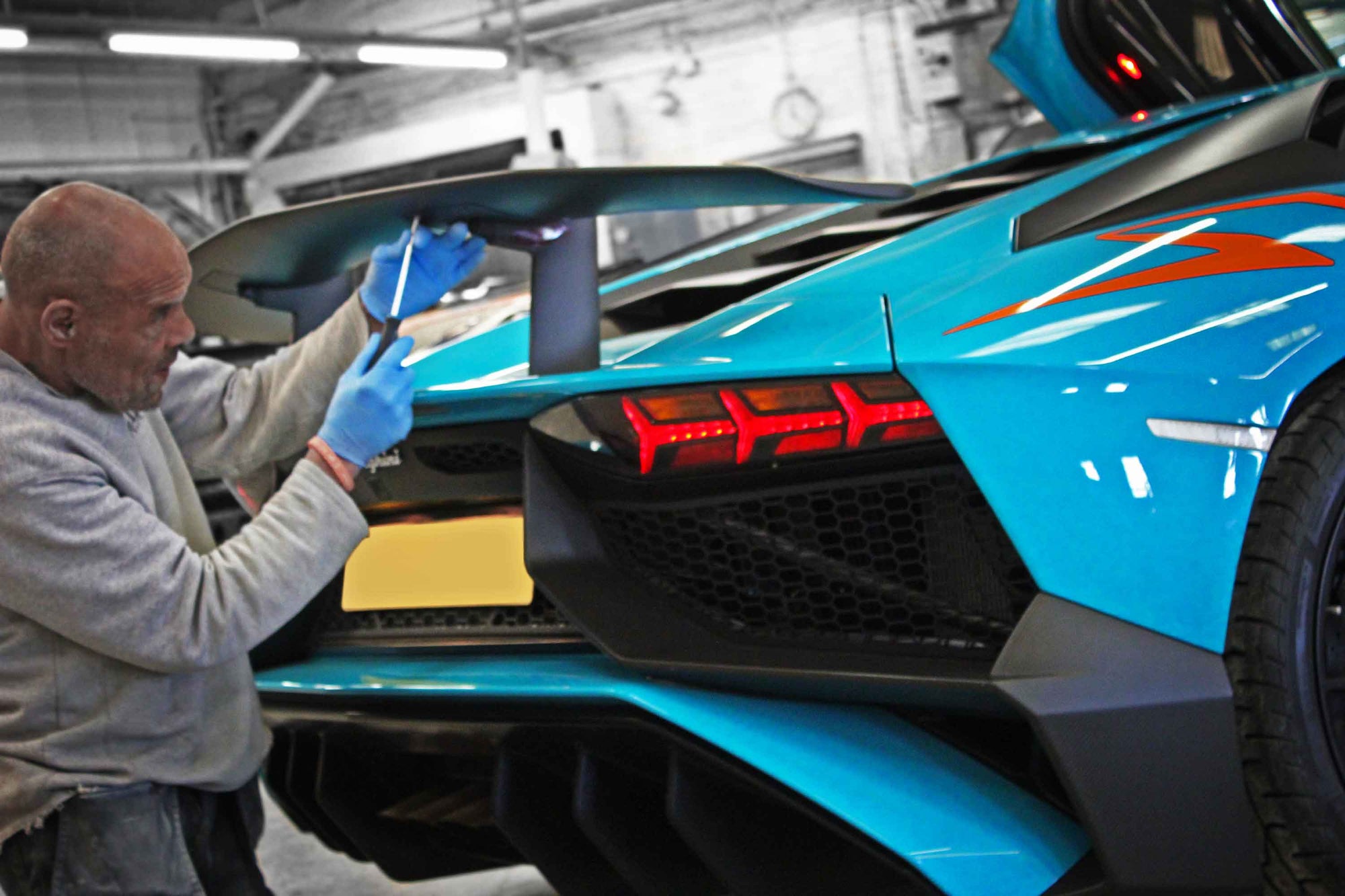 Person working on a Lamborghini Aventador SVJ supercar in the Enkahnz workshop