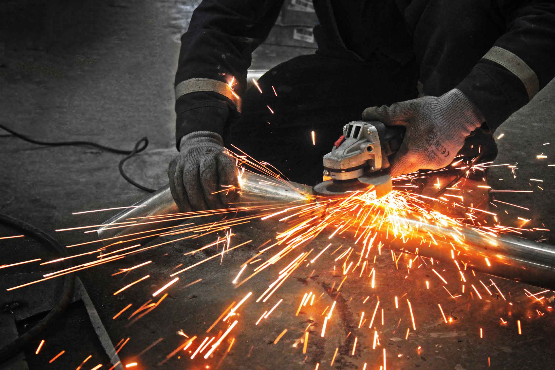 Person using a grinder with sparks flying in the Enkahnz workshop 