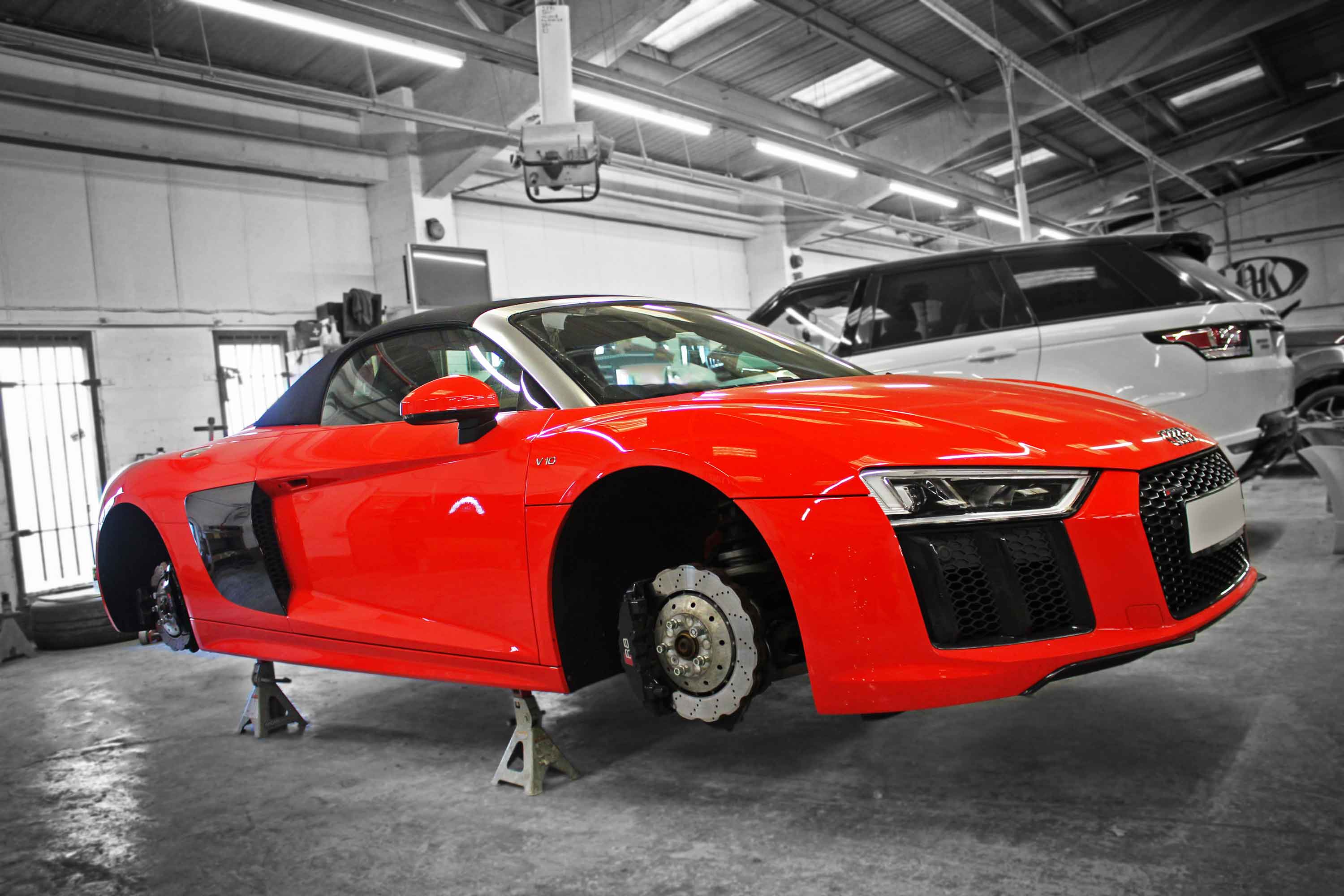 Red Audi  R8 4S supercar on jack stands in Enkahnz workshop.