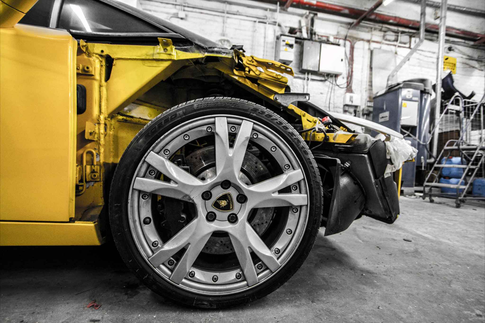 Close-up of a yellow Lamborghini Gallardo car's wheel shot inside the Enkahnz workshop.
