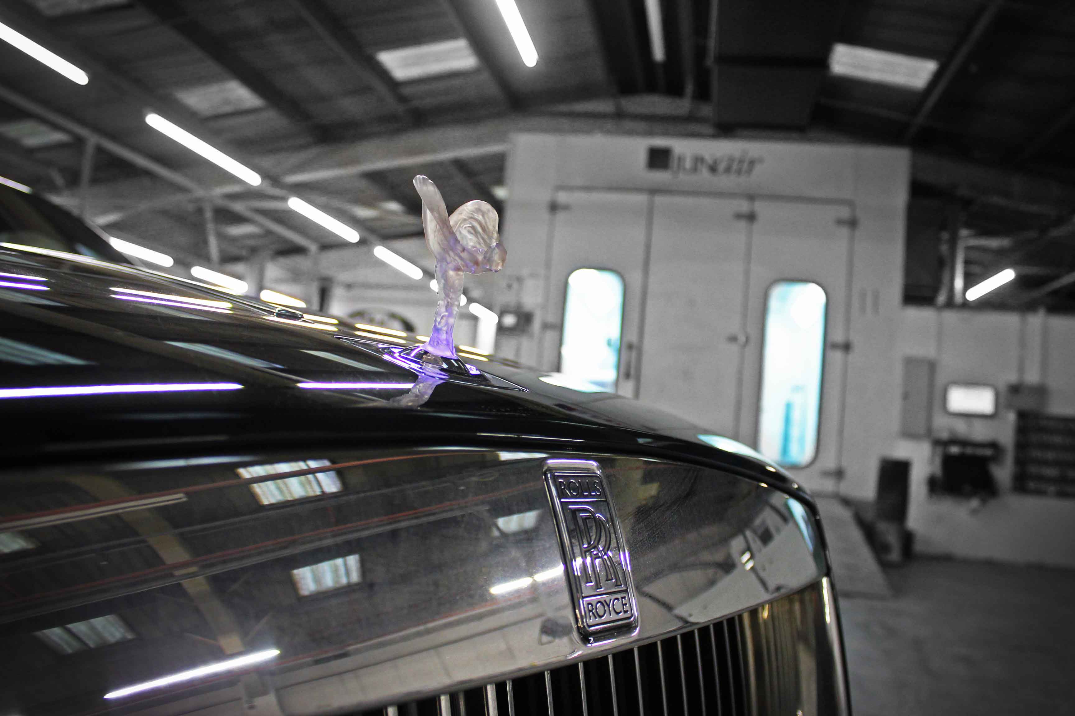 Rolls-Royce car with logo on a blurred background inside the Enkahnz workshop