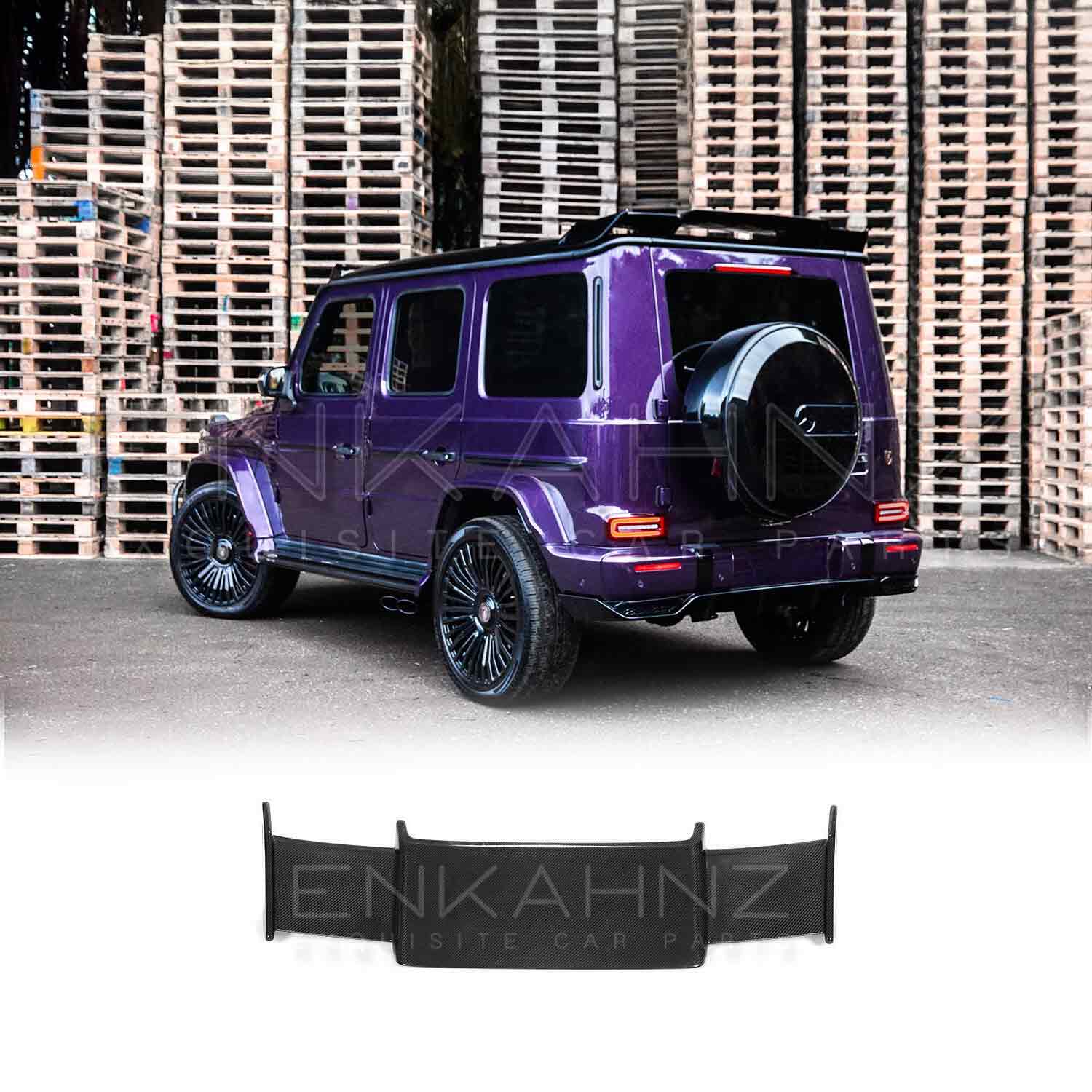 Rear quarter view of Purple Mercedes G Wagon G Class W463A SUV with gloss black wheels fitted with real Carbon Fibre BRBS style Rear Roof Spoiler in front of stacked pallets
