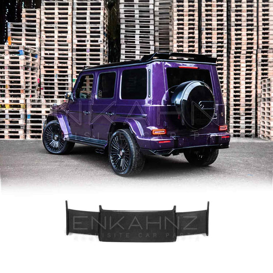 Rear quarter view of Purple Mercedes G Wagon G Class W463A SUV with gloss black wheels fitted with real Carbon Fibre BRBS style Rear Roof Spoiler in front of stacked pallets