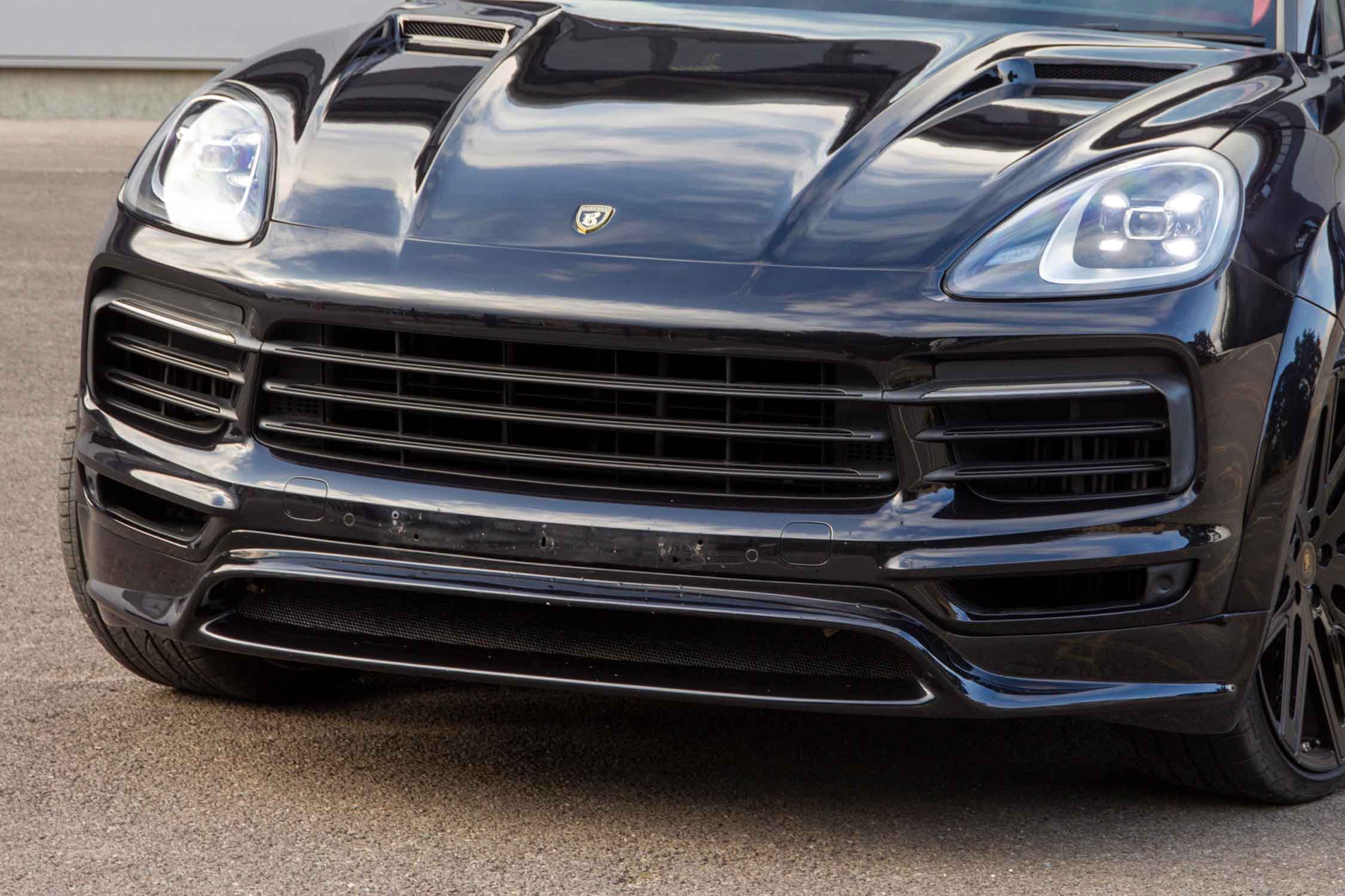 Close-up of a dark blue Porsche Cayenne, Barugzai Eleganza bodykit on a tarmacked floor 