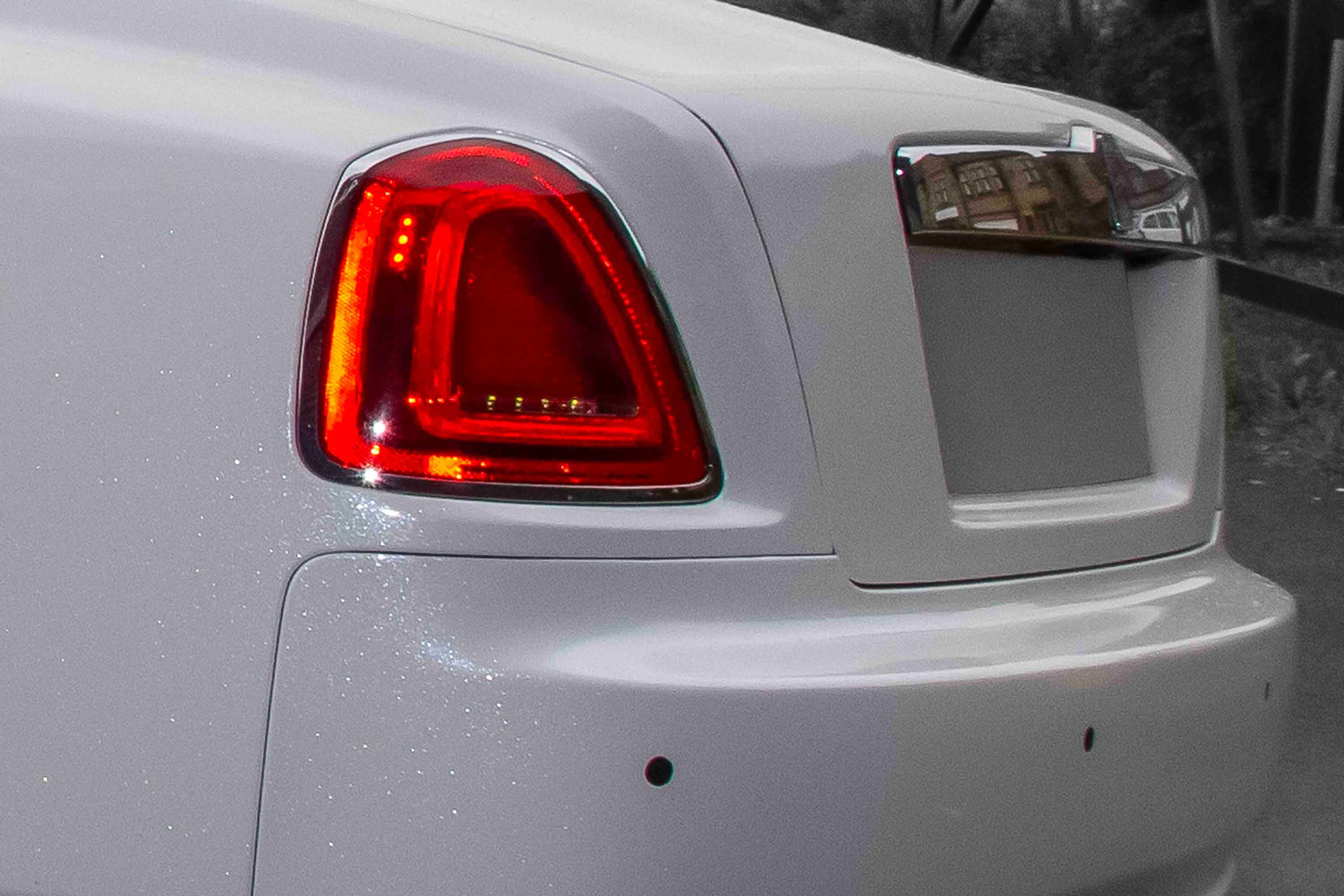 Close-up of a White Rolls Royce Wraith rear light and design details, vinyl wrap