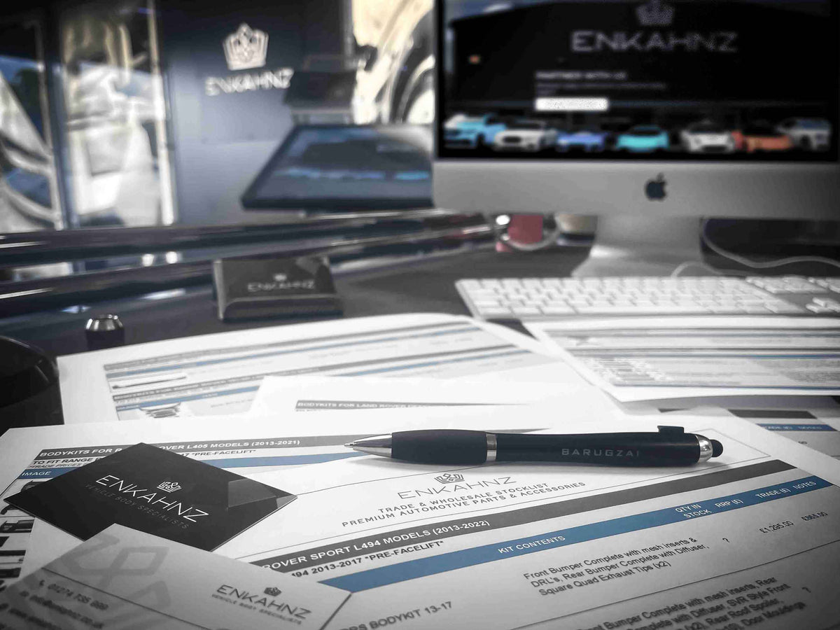 Desk with Enkahnz branded materials, computer, and Barugzai branded pen